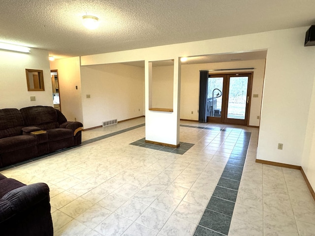 living room with a textured ceiling and french doors