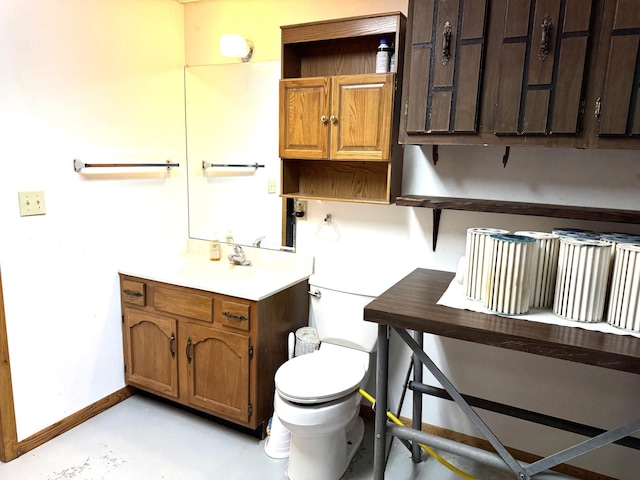 bathroom featuring vanity, concrete floors, and toilet