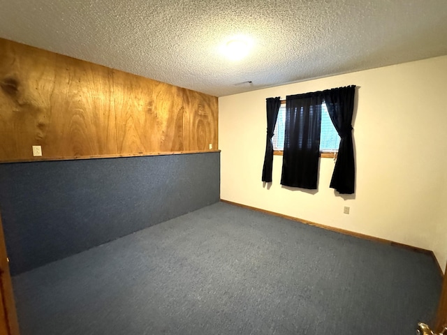 empty room with carpet flooring and a textured ceiling