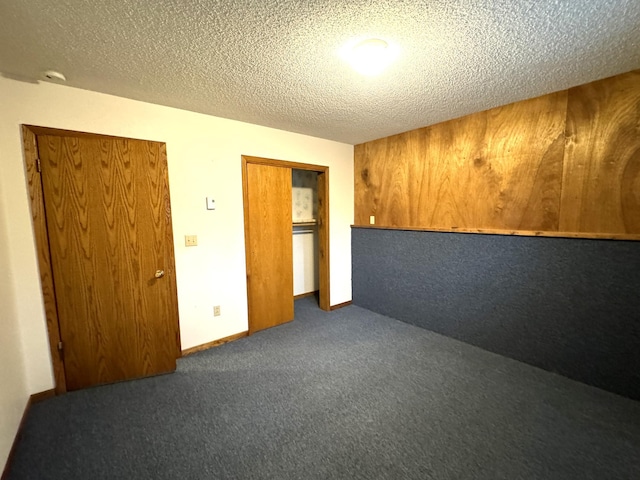 empty room featuring dark colored carpet and a textured ceiling