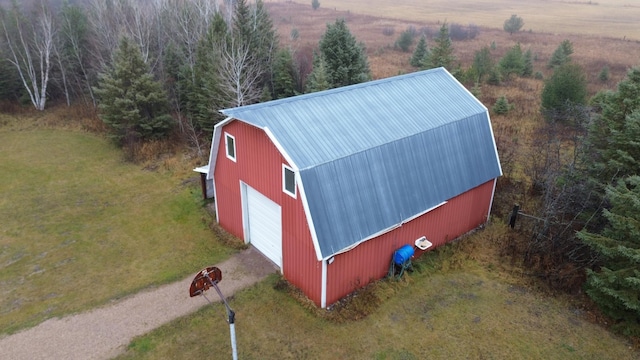 view of outdoor structure with a lawn, a rural view, and a garage