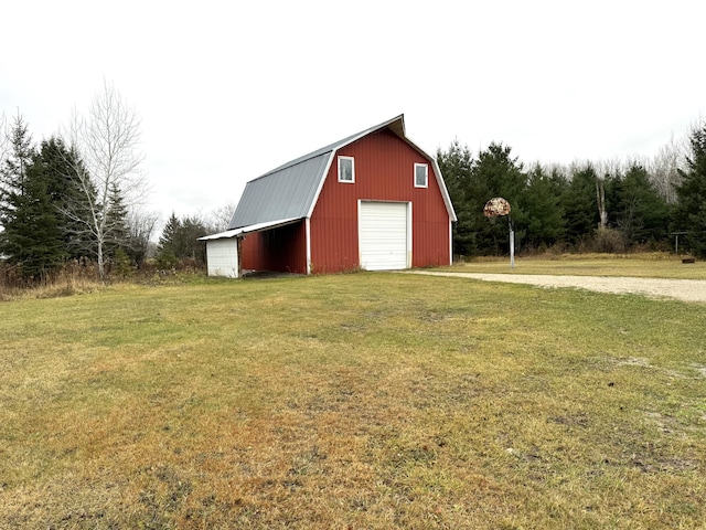 view of outdoor structure featuring a garage and a lawn