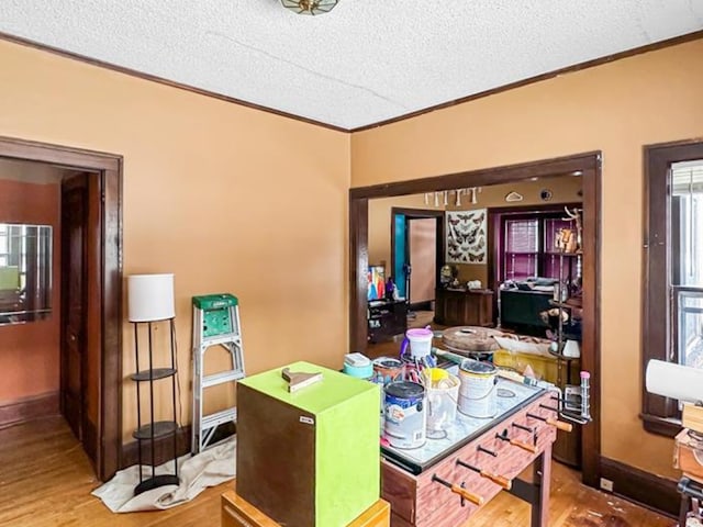 home office featuring baseboards, ornamental molding, a textured ceiling, and wood finished floors