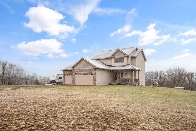 view of front facade with a front lawn, covered porch, and a garage