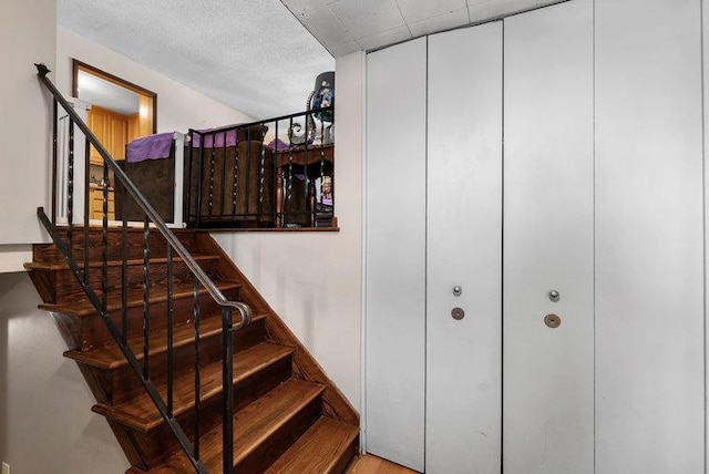 staircase with a textured ceiling