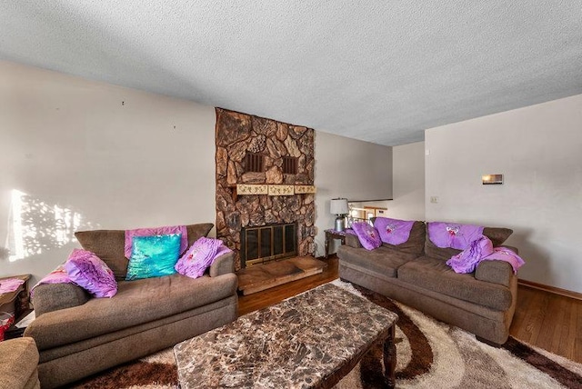 living room with a fireplace, a textured ceiling, and hardwood / wood-style flooring