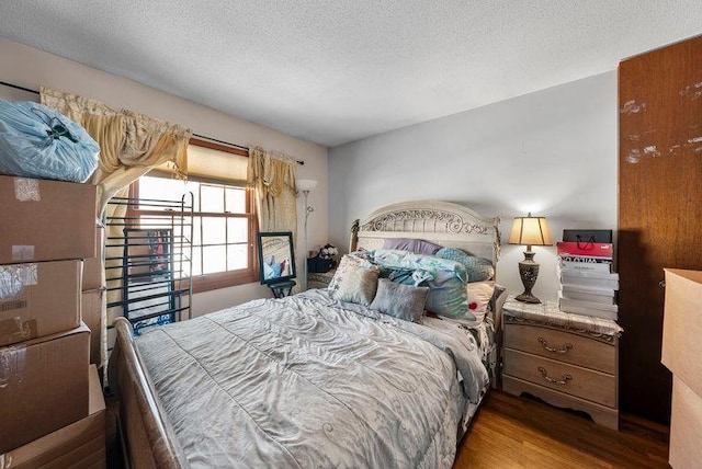 bedroom with a textured ceiling and hardwood / wood-style flooring