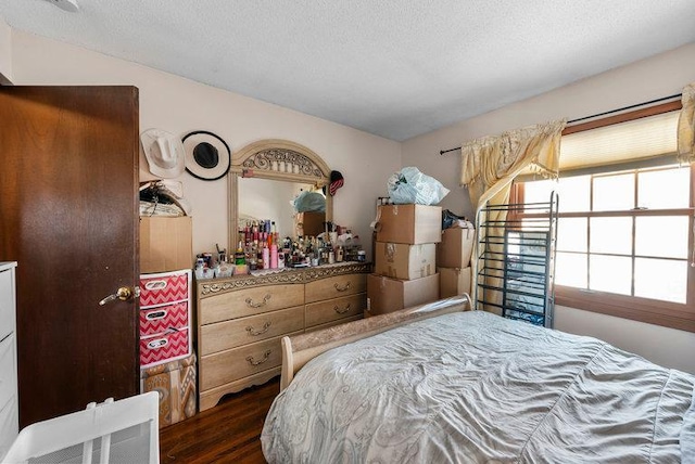 bedroom featuring dark hardwood / wood-style flooring and a textured ceiling