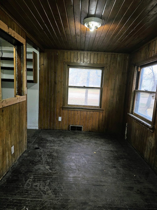 spare room featuring wood walls, a wealth of natural light, and wooden ceiling