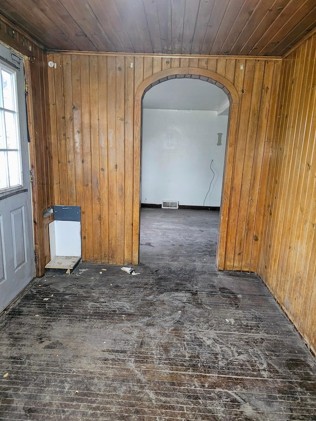 unfurnished room with wood walls and wooden ceiling