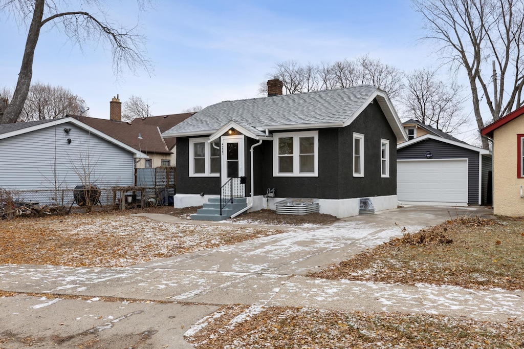 view of front of property featuring a garage and an outdoor structure