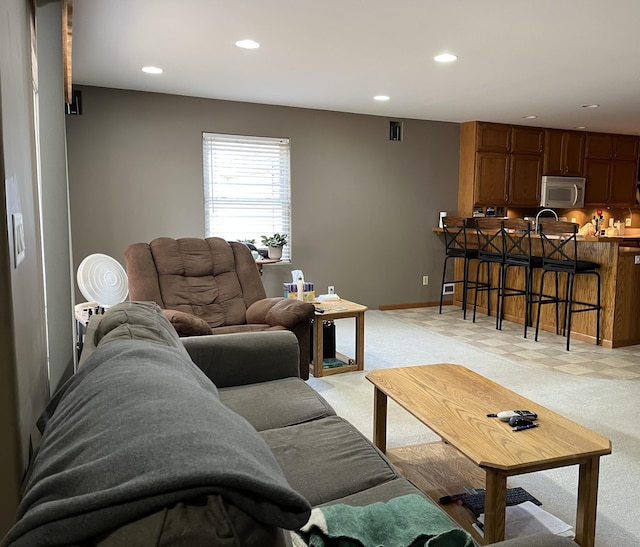 carpeted living room featuring sink