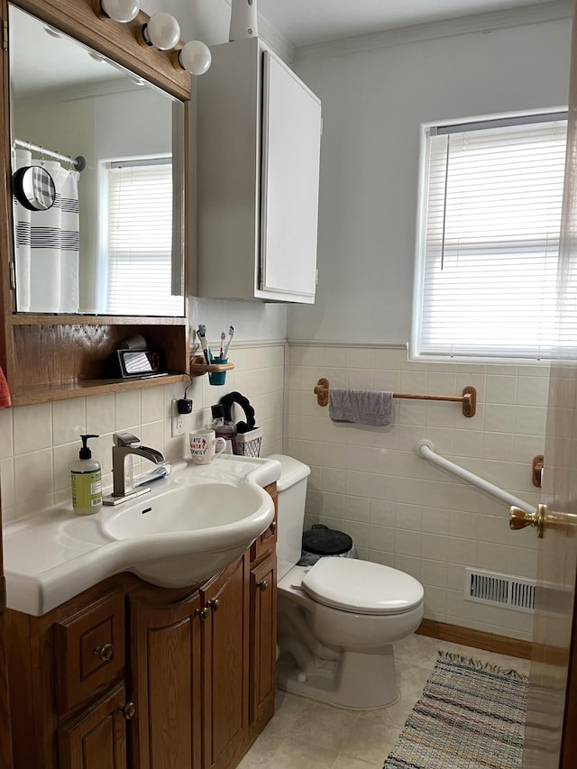 bathroom featuring vanity, tile patterned floors, toilet, and tile walls