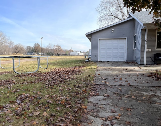 view of side of home with a lawn and a garage