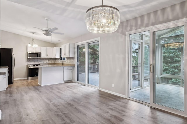 kitchen with white cabinets, light hardwood / wood-style flooring, stainless steel appliances, and backsplash