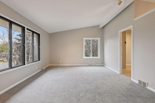 spare room featuring vaulted ceiling and carpet flooring