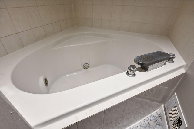 bathroom with tiled tub and tile patterned floors