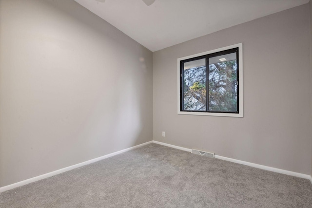 carpeted empty room with lofted ceiling