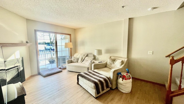 living area featuring a textured ceiling and light hardwood / wood-style flooring