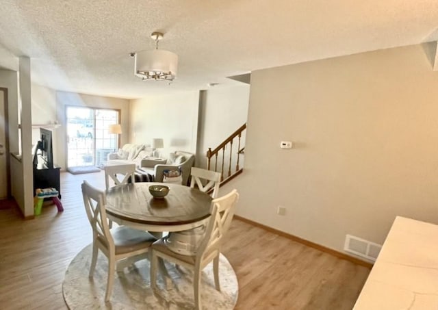 dining space with a textured ceiling and hardwood / wood-style floors