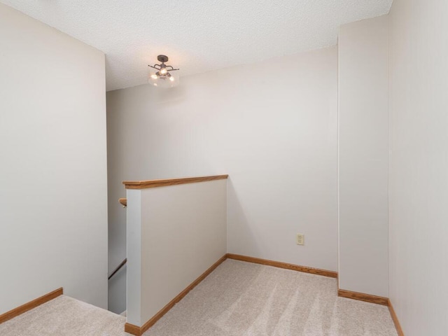 carpeted empty room featuring a textured ceiling