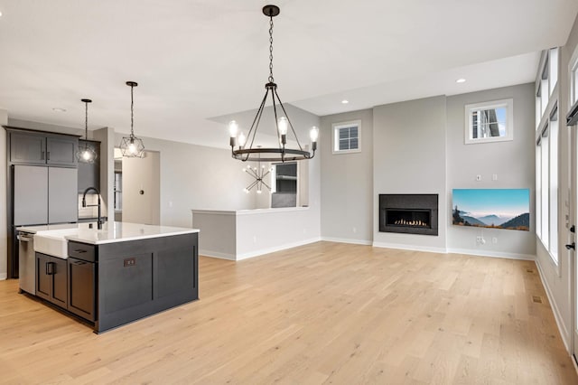 kitchen featuring plenty of natural light, an island with sink, and hanging light fixtures