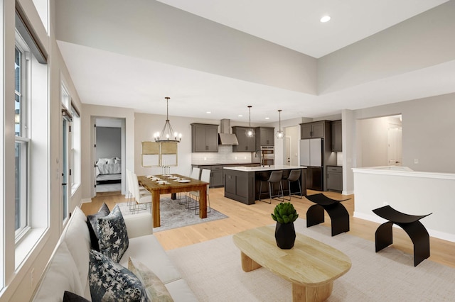 living room with a chandelier, sink, and light wood-type flooring