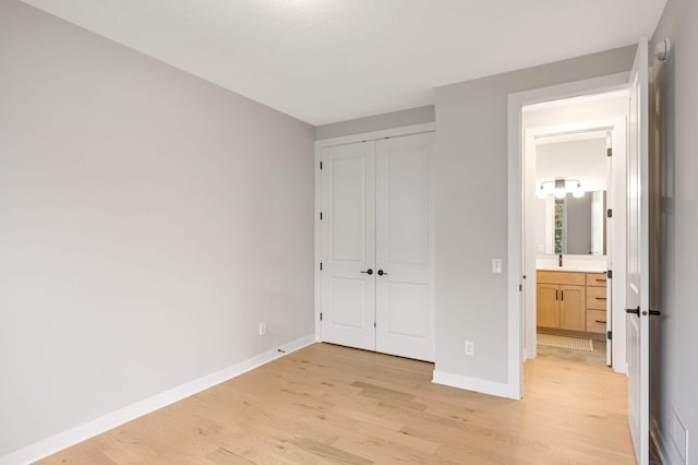 unfurnished bedroom with a closet and light hardwood / wood-style flooring