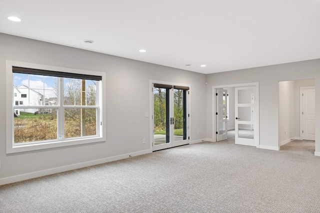 unfurnished room with light colored carpet and french doors