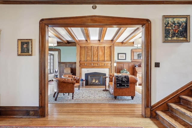 living room featuring beam ceiling and light hardwood / wood-style flooring