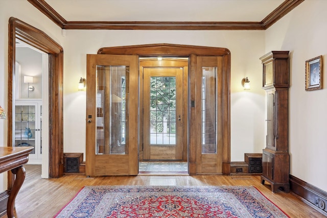 foyer featuring french doors, light hardwood / wood-style floors, and ornamental molding