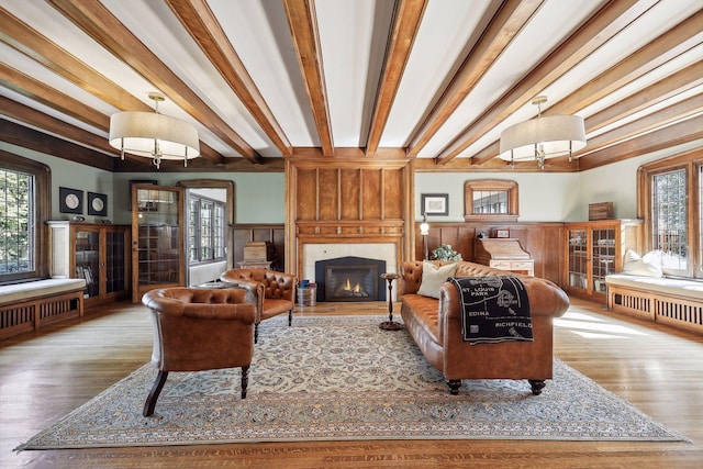 living room featuring beamed ceiling, hardwood / wood-style flooring, and plenty of natural light