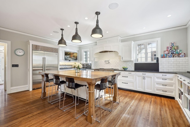 kitchen with white cabinets, a healthy amount of sunlight, and light hardwood / wood-style floors