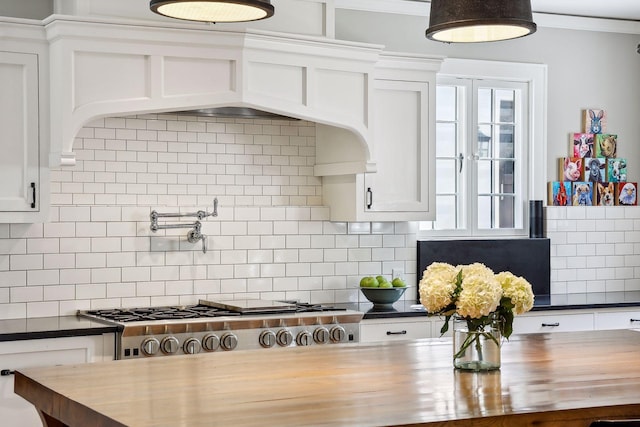 kitchen with wood counters, white cabinets, and tasteful backsplash