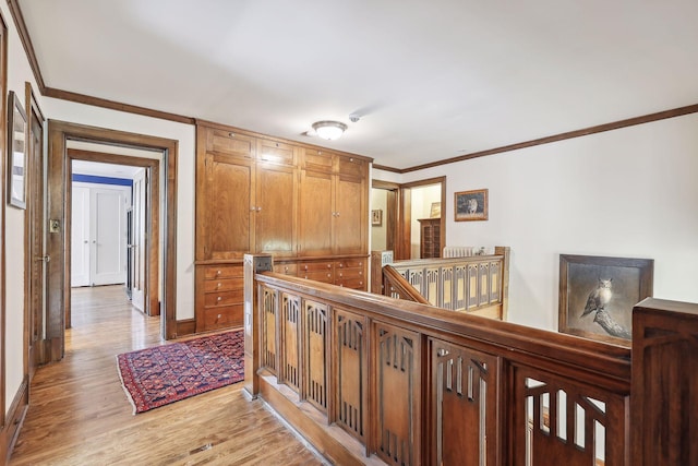 hall with light wood-type flooring and crown molding