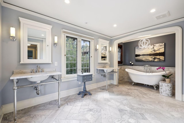 bathroom with a washtub, double sink, and ornamental molding