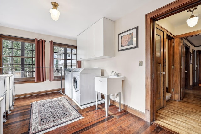 laundry area with dark hardwood / wood-style flooring, cabinets, and independent washer and dryer