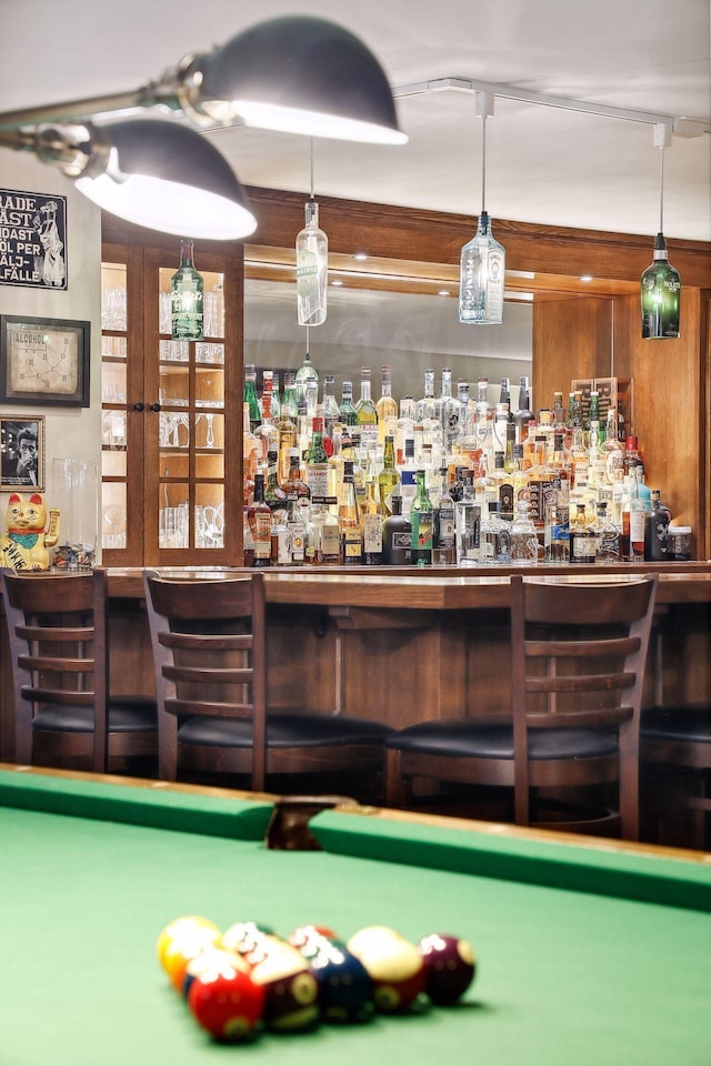 bar featuring rail lighting, hanging light fixtures, and pool table