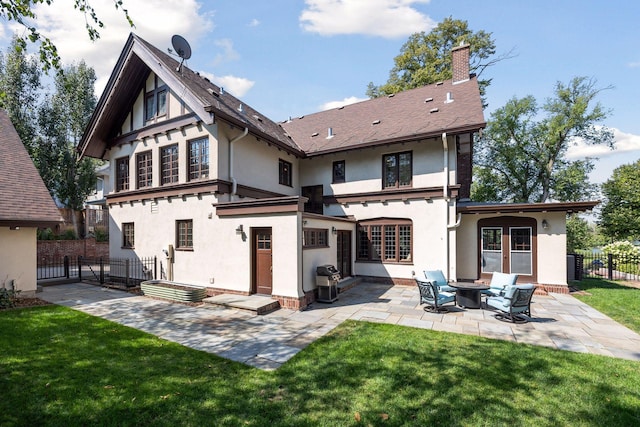 back of property featuring a lawn and a patio