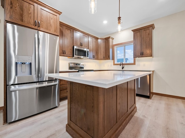 kitchen with pendant lighting, light wood-type flooring, appliances with stainless steel finishes, and a center island