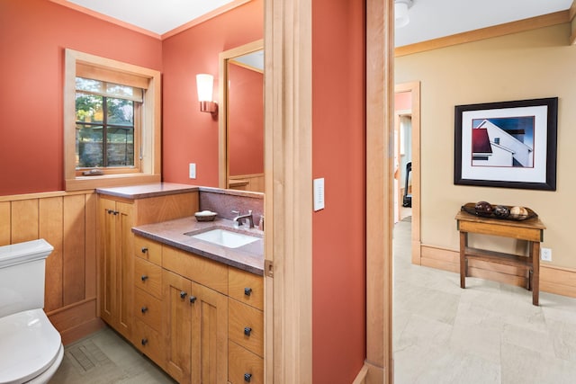 19752 Halwood Rd, Glenwood Twp, MN 56334 - bathroom with toilet, vanity, and a wainscoted wall
