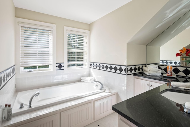 19752 Halwood Rd, Glenwood Twp, MN 56334 - full bathroom featuring vanity, a garden tub, tile walls, and a wainscoted wall