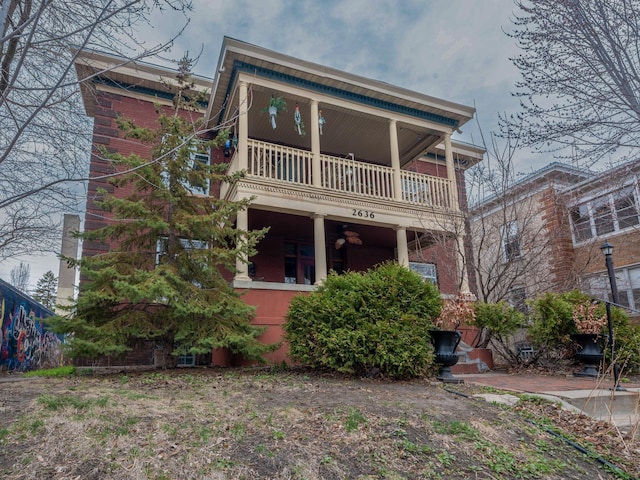 view of front of house with brick siding and a balcony