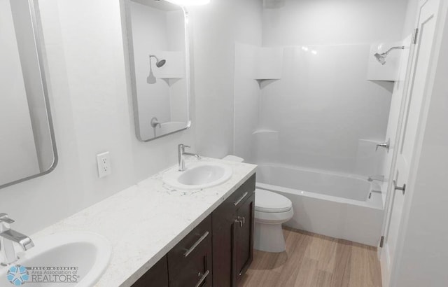 full bathroom with vanity, toilet, hardwood / wood-style flooring, and shower / bathtub combination