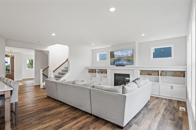 living room featuring a wealth of natural light and dark hardwood / wood-style flooring