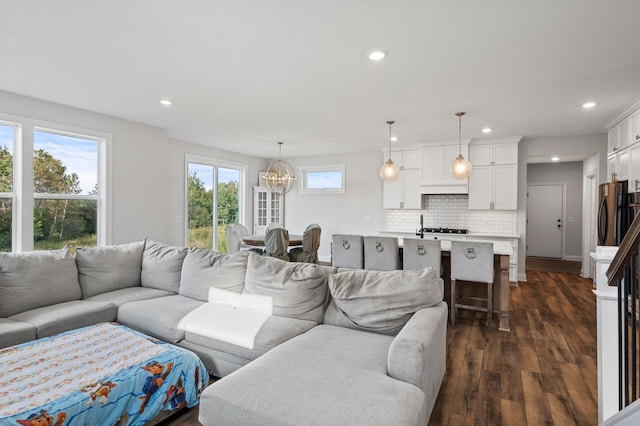 living room featuring dark wood-type flooring and a chandelier