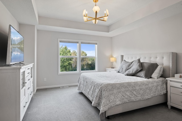 carpeted bedroom featuring an inviting chandelier and a raised ceiling