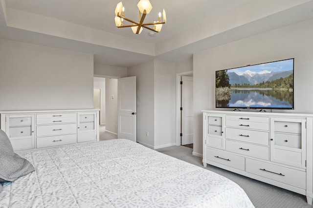 carpeted bedroom with an inviting chandelier and a raised ceiling