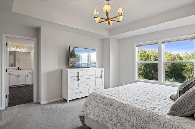 carpeted bedroom with connected bathroom, sink, multiple windows, and a notable chandelier