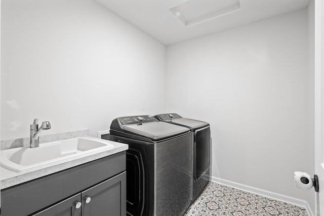 washroom featuring sink, washer and clothes dryer, and cabinets